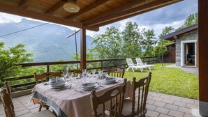 An outdoor dining area with a table set for six, overlooking a mountainous landscape. - Moncucco Mountain Home by Interhome (Valtellina)