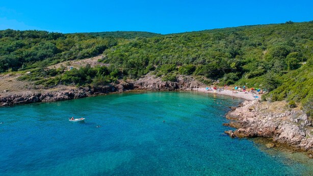A coastal area with clear turquoise water, rocky shorelines, and lush green hills in the background. - Le Maris by Interhome (Krk/Dobrinj)