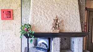 A stone fireplace with a decorative plant and a small statue. - Wohnung 421 Seeblick by Interhome (Strobl)