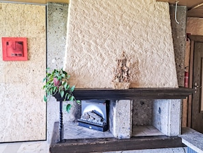 A stone fireplace with a decorative plant and a small statue.