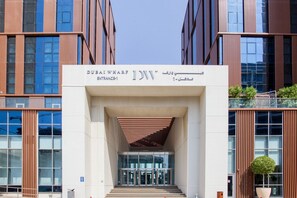 The entrance to the Dubai Wharf JW Marriott hotel with a modern architectural design, featuring a prominent entrance canopy and glass doors. - Blueground | Jaddaf Waterfront, pool, nr Dubai Canal (Dubai)