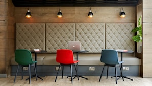A seating area with a tufted backrest, three chairs, a laptop on a small table, and pendant lighting. - For Students Only - Modern Rooms in Lincoln (Lincoln)