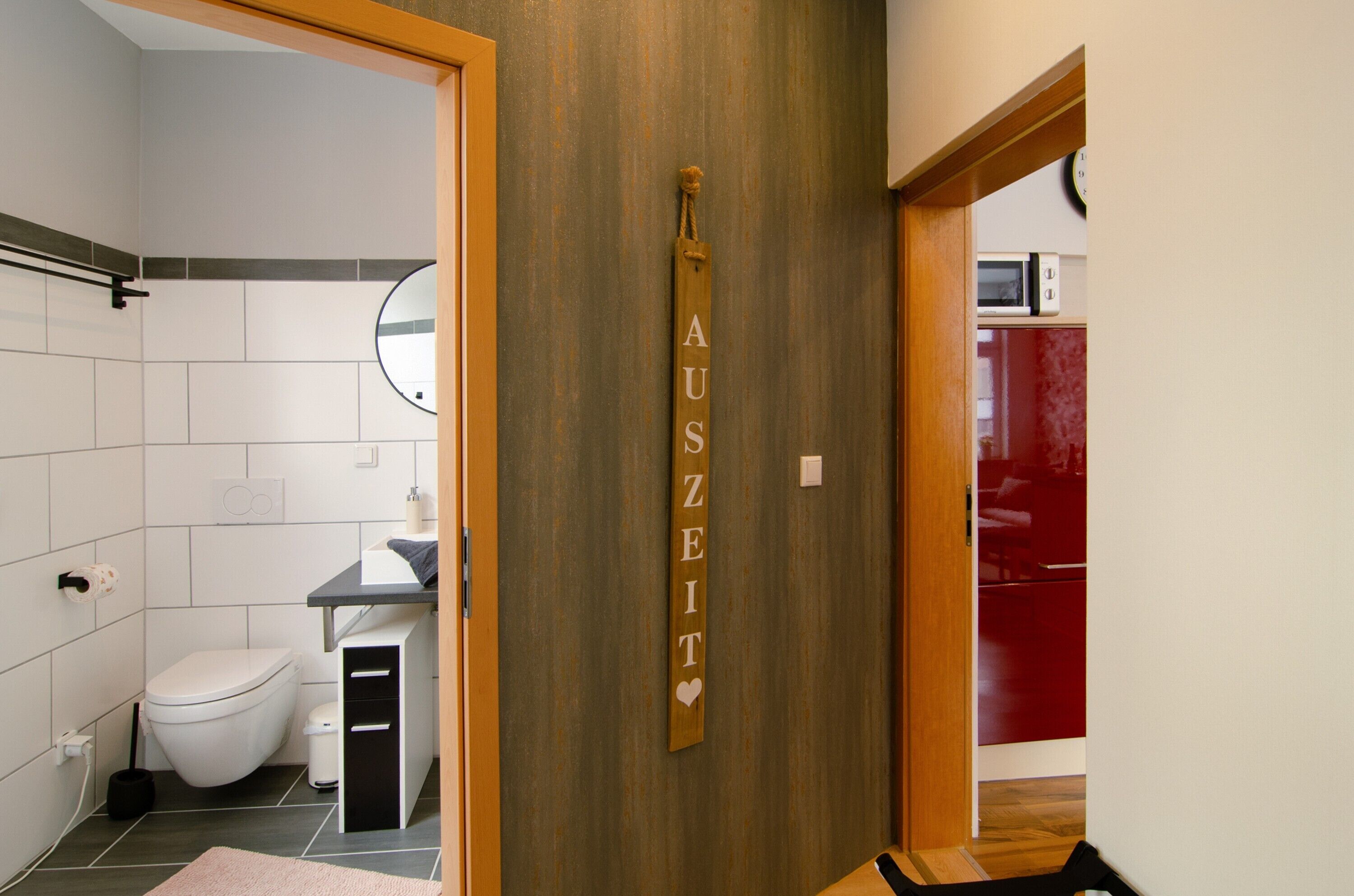 Un baño con inodoro, lavamanos y una pared de madera con un letrero.