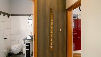 Un baño con inodoro, lavamanos y una pared de madera con un letrero.