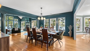 Une salle à manger spacieuse avec une grande table en bois, dressée pour six personnes, entourée de chaises en bois foncé.