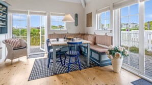 A cozy kitchen with a wooden table, blue chairs, and a striped bench.