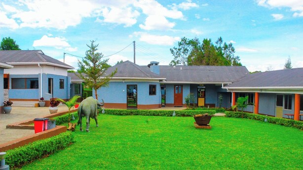 A residential area with houses, a well-maintained lawn, and a small garden area. - Holiday Premier Hotel (Ol Kalou)