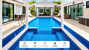 Un espace piscine moderne avec une grande piscine bleue, 4 chambres, un très grand jardin et un environnement paisible.