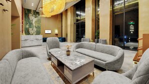 A modern lobby with grey sofas, a marble coffee table, and a large chandelier. - Rajawat The Fern An Ecotel Hotel (Akbarpur)