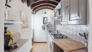 Una cucina con schienale piastrellato, fornello, forno a microonde e lavello.