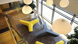 A modern interior with a glass railing, a staircase, and a seating area with yellow and gray chairs. - For Students Only - Modern Rooms in York (York)