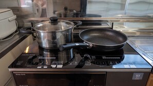 A kitchen with induction heating, a wide grill, and a frying pan on the stove. - STAY IN TOKIWA (Asahikawa)