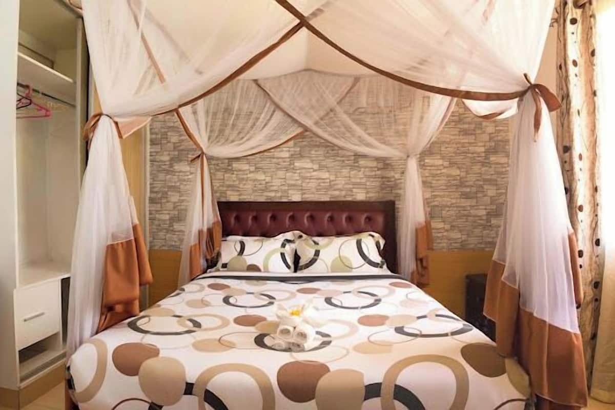 Una camera da letto con un letto a baldacchino, un muro in pietra e un armadio.