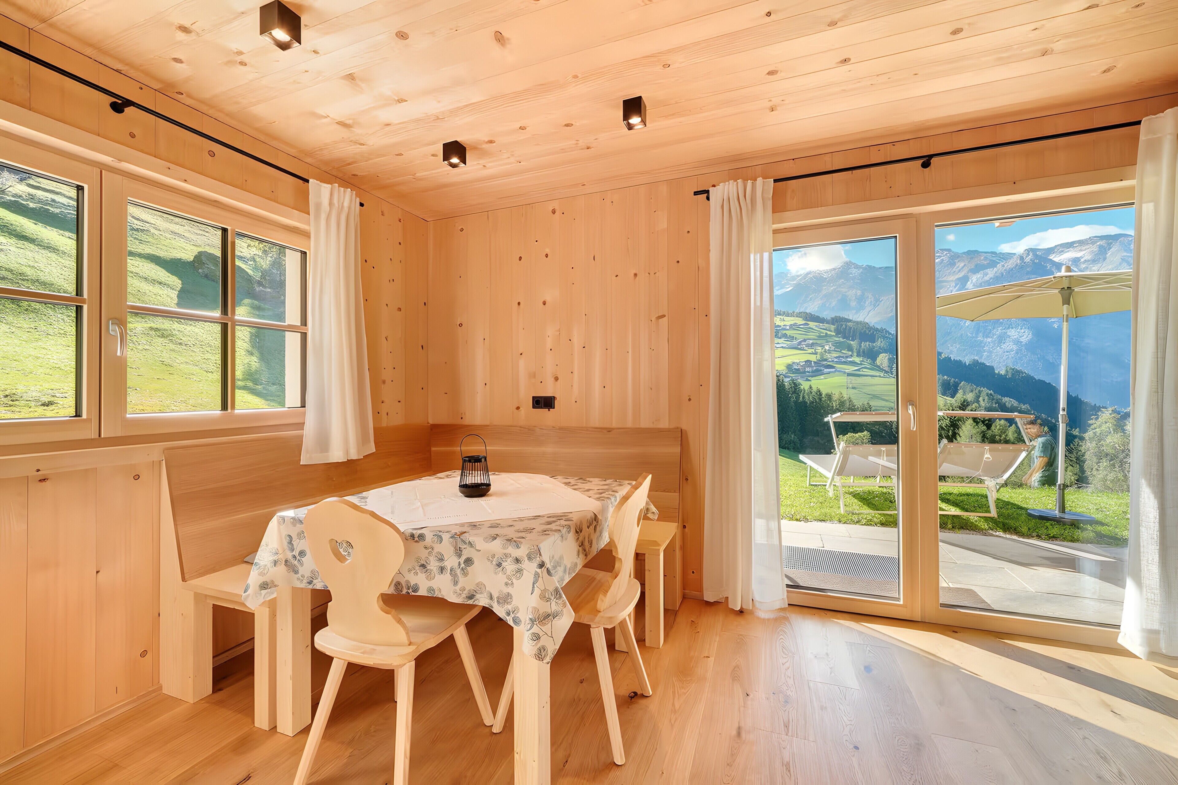 A wooden interior with a dining table, chairs, and a bench.