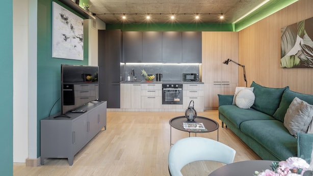 Una sala moderna con un sofá gris, una mesa de centro y un televisor.
