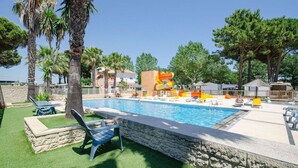 Une piscine équipée de chaises longues et d’un toboggan aquatique.