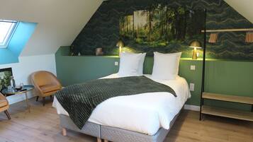 A bedroom with a bed, a chair, a desk, and a wall mural.