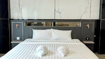 Ein Hotelzimmer mit einem großen Bett, zwei Nachttischen, einer Marmorwand und einem modernen Design.