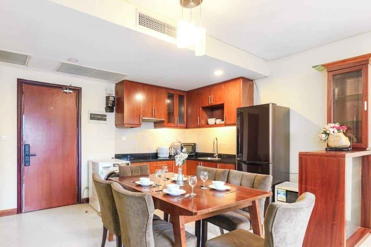 Una cucina moderna con mobili in legno, un tavolo da pranzo per quattro persone e un forno integrato.