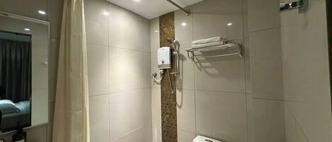 A modern bathroom with a shower, toilet, and sink.