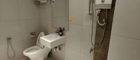 Ein modernes Badezimmer mit Toilette, Waschbecken und Dusche.