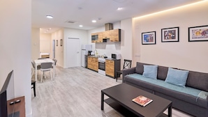 A modern apartment with a living room, kitchenette, and dining area. - Apartamento Catedral Palace by gaiarooms (Valladolid)