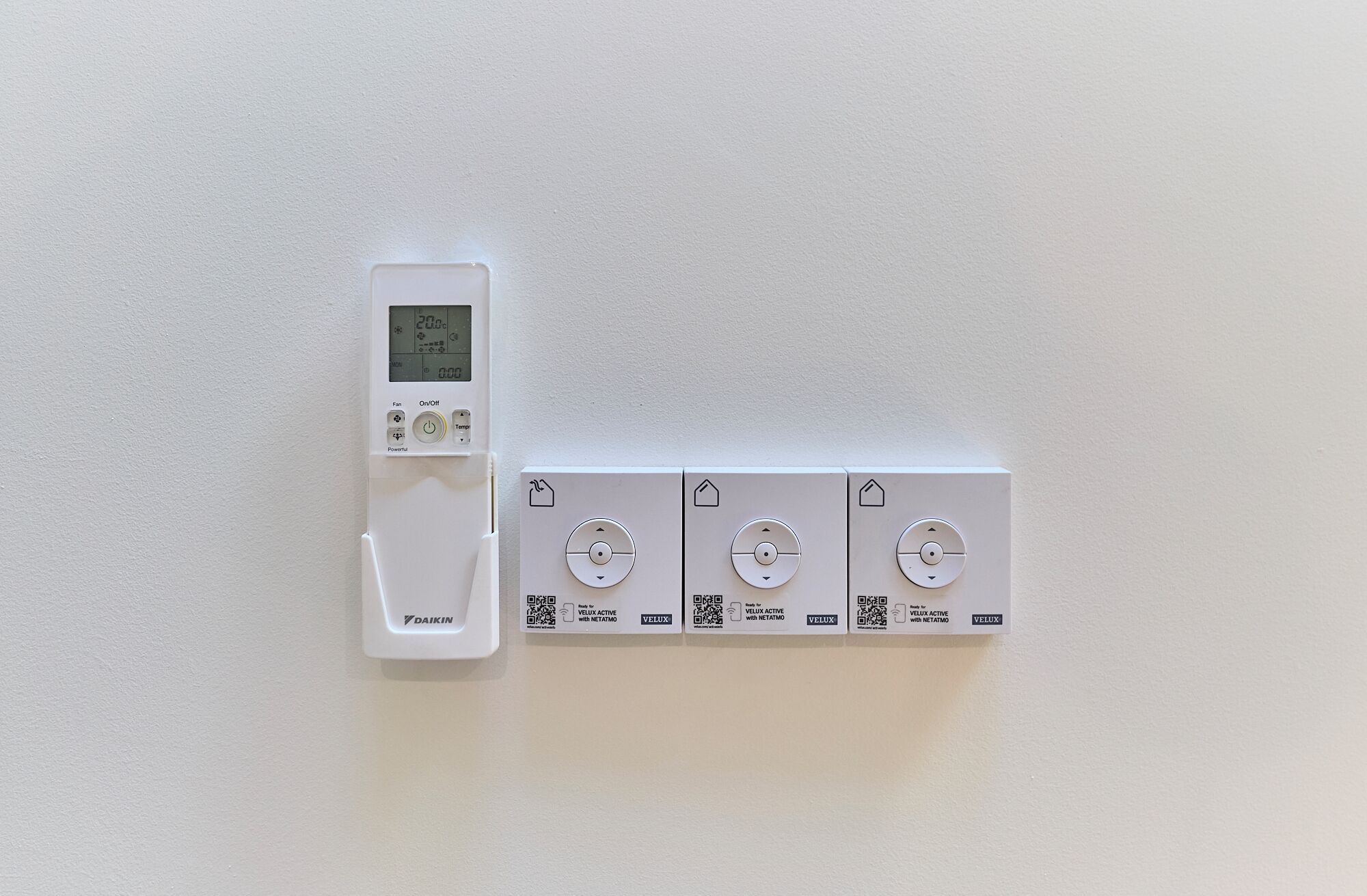 A thermostat and four Velux windows on a wall.