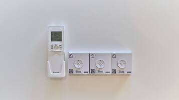 A thermostat and four Velux windows on a wall.