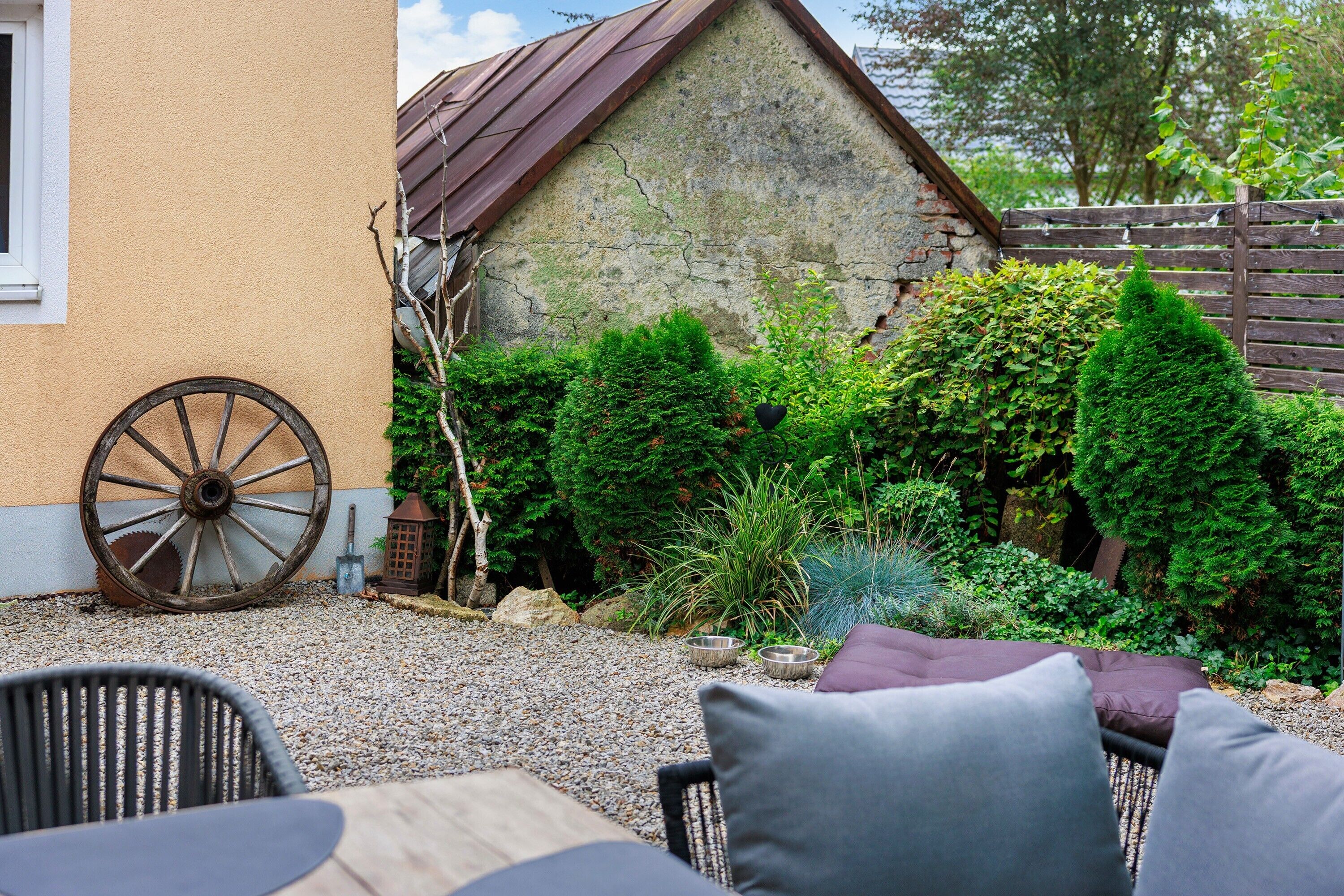 A patio with outdoor furniture, a stone wall, and a wooden fence.