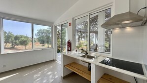 A modern kitchen with large windows, a fire extinguisher, and a built-in stove. - Casa do Monte by Check-in Portugal (Albufeira)