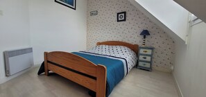 Tabla de planchar con plancha y ropa de cama