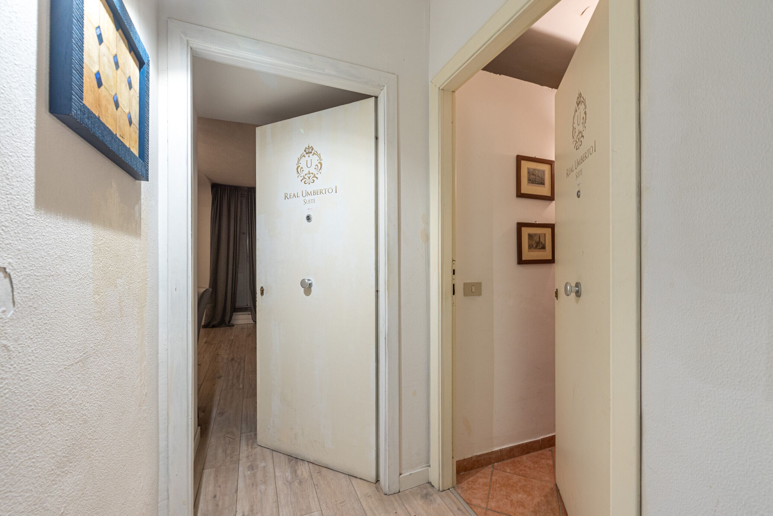 Un pasillo con puertas que indican "Real Umberto I Suite".