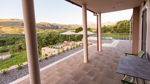 A covered outdoor area with a pool, seating, and a view of the mountains. - Kera Koxare Luxury Villa, Private Pool and Panoramic Mountain Views (Koxare Agiou Vasileiou)