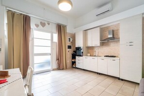Uma cozinha moderna com armários brancos, um fogão e um micro-ondas.