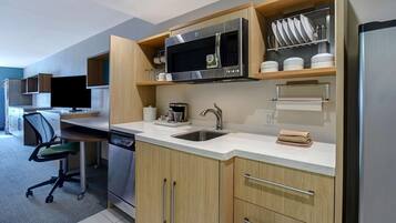 Een koelkast, een microgolfoven, kookgerei, borden en bestek