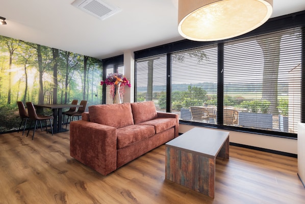 Studiosuite – junior, terrasse, utsikt mot høyde | Oppholdsområde | En 50-tommers smart-TV med digitale kanaler