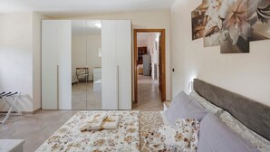 A bedroom with a bed, a wardrobe, a mirror, and a hallway leading to a living area. - Apartment 'Prima Luce' with Sea View, Private Terrace and Wi-Fi (Vico Equense)