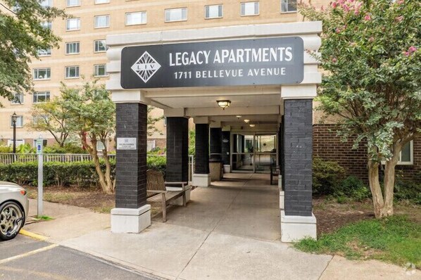 Entrada de un edificio con un cartel que dice 'Legacy Apartments, 1711 Bellevue Avenue'.