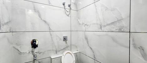 A bathroom with a toilet, bidet, and shower.