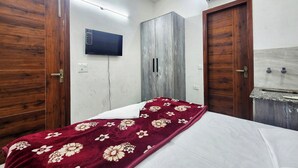 Een slaapkamer met een bed, een kledingkast, een televisie en een airconditioning.
