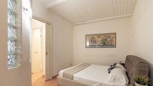 A bedroom with a bed, a potted plant, and a painting on the wall. - Real Umberto I Suite 2 by Wonderful Italy (Palermo)