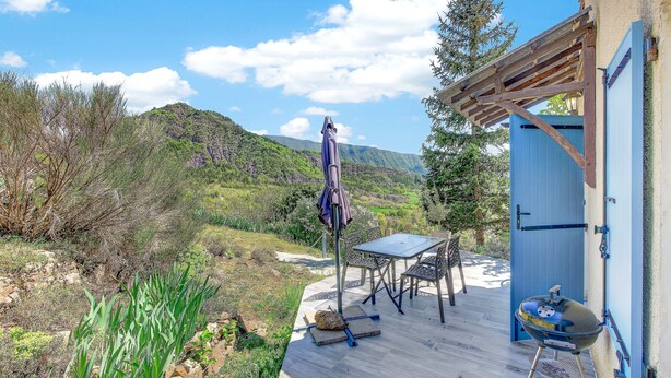 A patio with a table and chairs, a grill, and a pergola with an umbrella. - Holiday Home 'Les Iris' with Mountain View, Private Terrace and Wi-Fi (La Robine-sur-Galabre)
