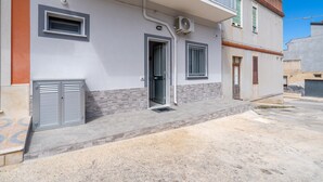 A residential building with a front door, two windows, and an air conditioning unit. - Apartment 'Perla  2' with Shared Terrace, Wi-Fi and Air Conditioning (Pachino)