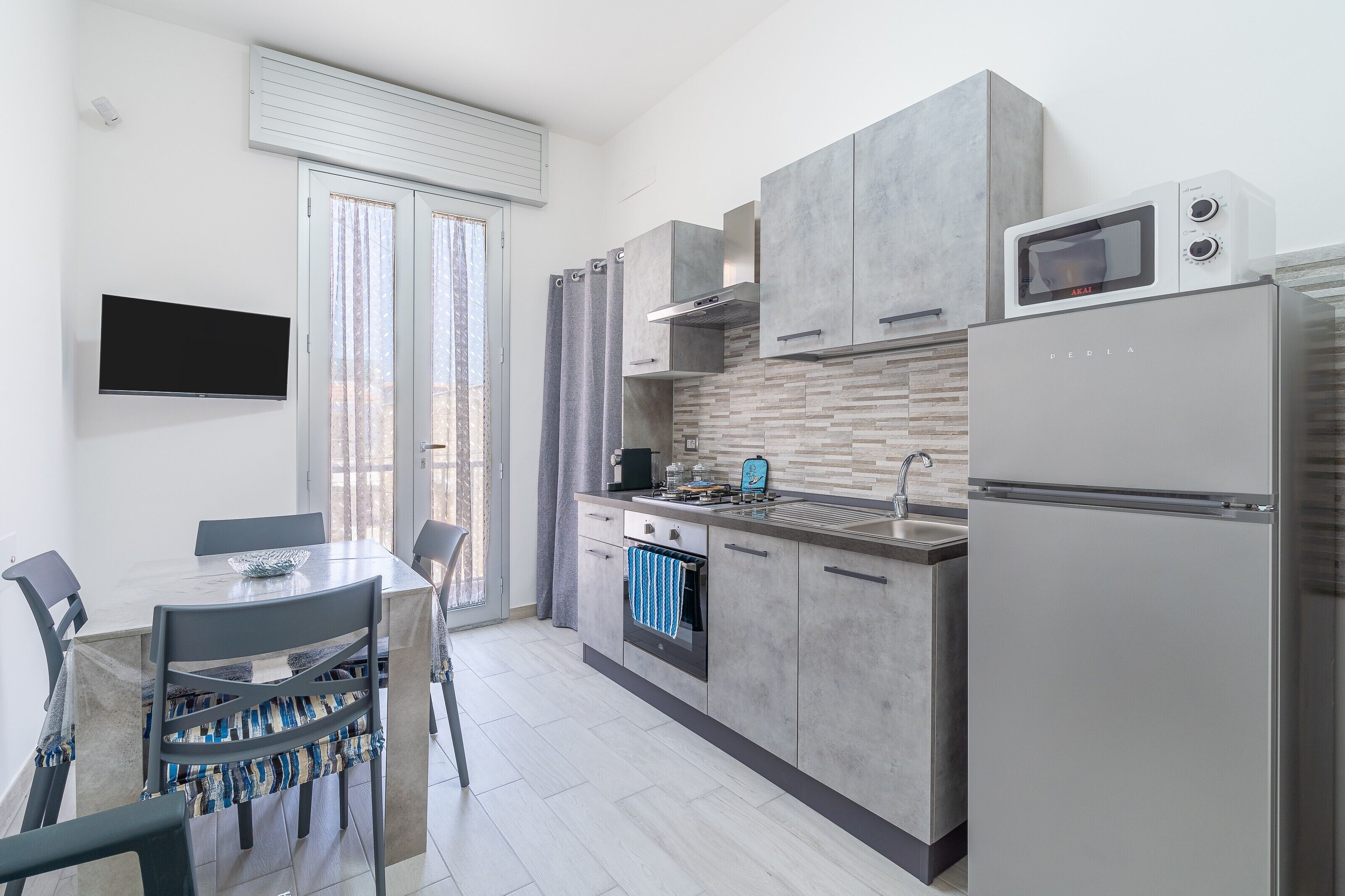A modern kitchen with a built-in microwave, oven, and refrigerator.