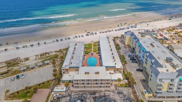 A beachfront hotel with a swimming pool, parking, and beach access. - Beachfront Comfort w/ Pool, Patio & Steps to Flagler Avenue (New Smyrna Beach)