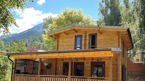 Eine Holzhütte mit Balkon, großen Fenstern und Bergblick.