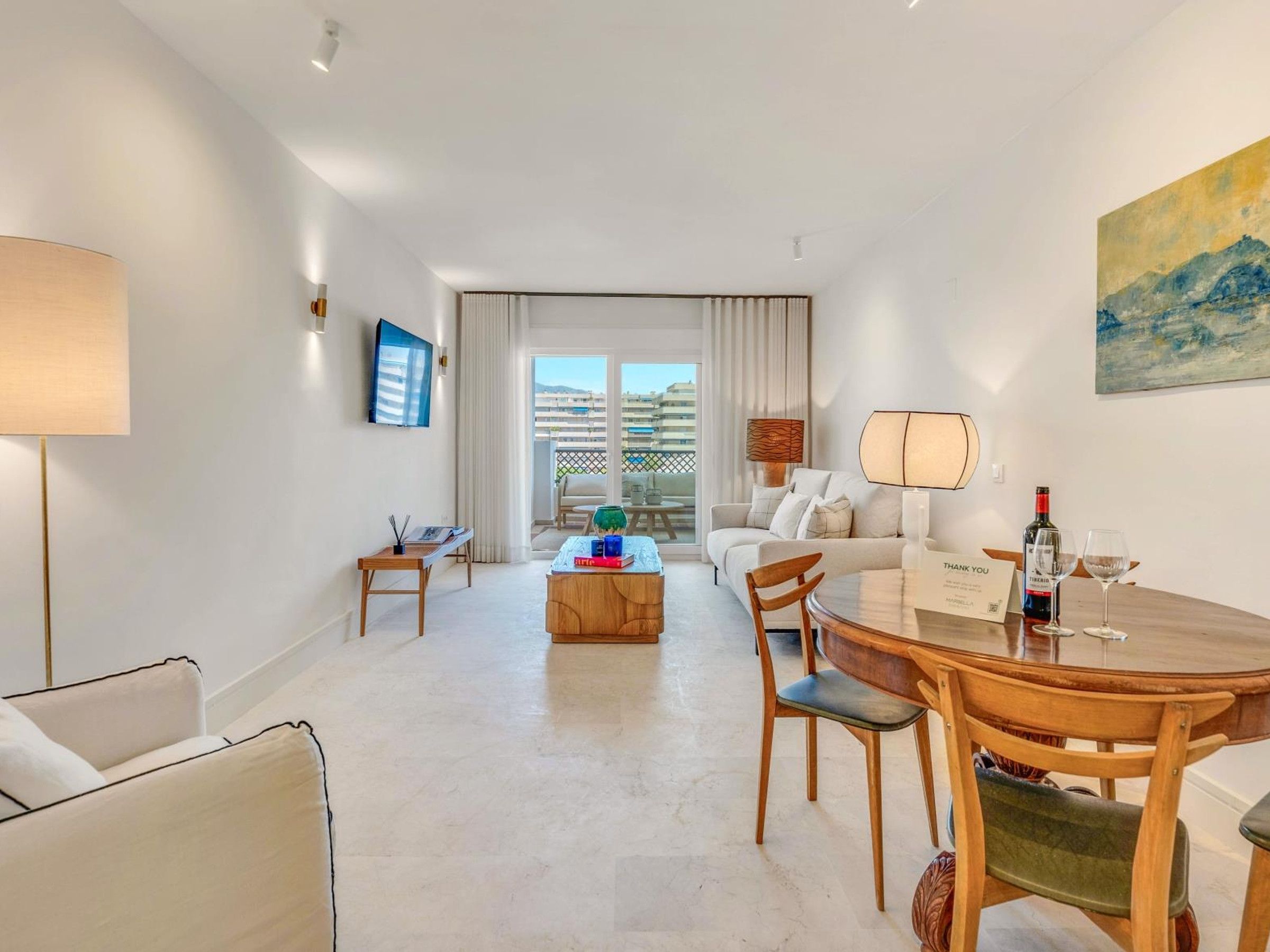 Ein modernes Hotelzimmer mit Essbereich, einer Couch, einem Couchtisch und einem Balkon mit Aussicht.