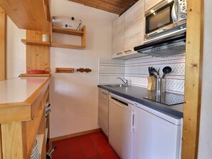 A compact kitchen with a microwave, oven, and dishwasher. - 2* Apartment Méribel, South, Ski-in, 5 pers. (Méribel)