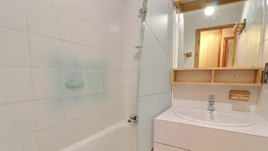 Een badkamer met een bad, een wastafel en een spiegel.