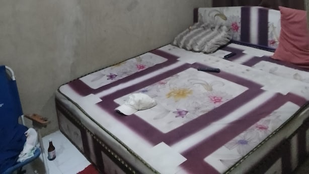 Une chambre à coucher avec un lit, un ventilateur de plafond et un luminaire suspendu.